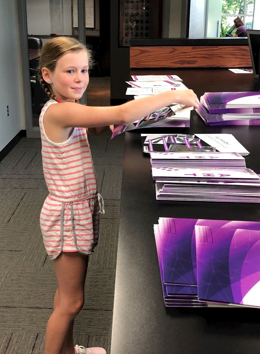 Nina helping to stuff marketing folders at AHT